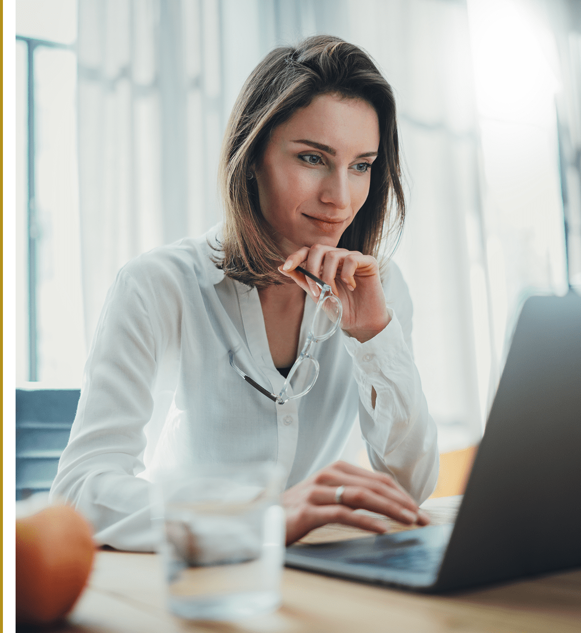 Woman working on laptop at desk.