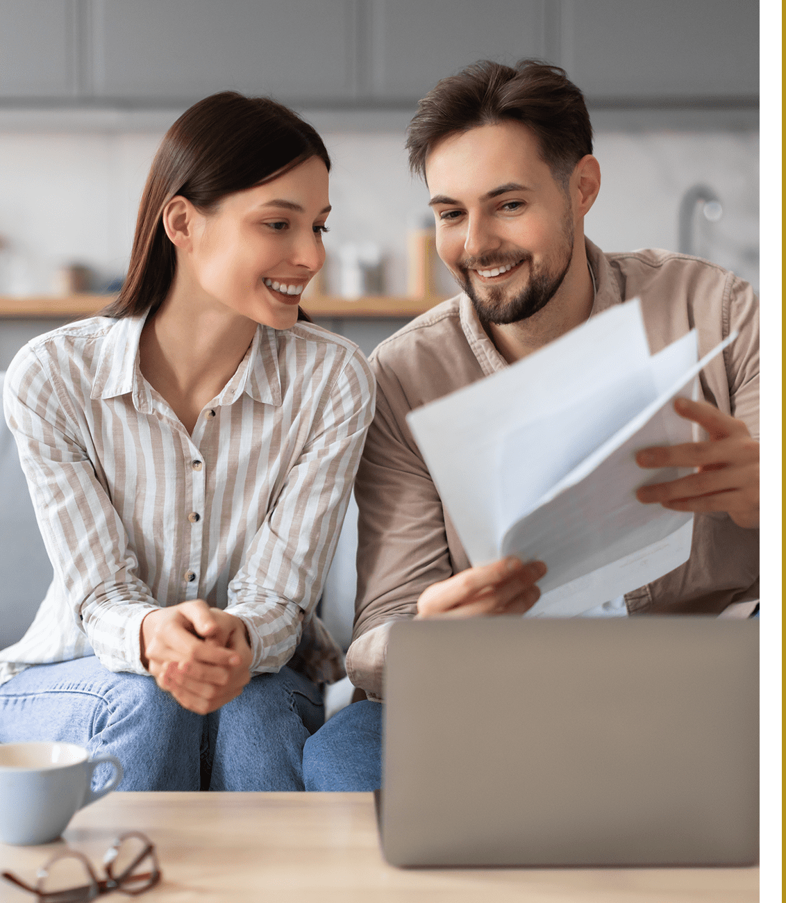 Couple reviewing documents together on laptop.